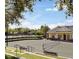 Well-maintained tennis court, benches, and clubhouse in a community with mature landscaping at 7652 Whisper Way # 104, Reunion, FL 34747