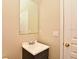 This bathroom has a single vanity and a mirror with decorative lighting, next to a closed door at 77 Spring Glen Dr, Debary, FL 32713
