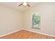Cozy bedroom features a window with a wooded view, laminate flooring, and light beige walls at 77 Spring Glen Dr, Debary, FL 32713
