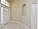 Inviting foyer with tile flooring, arched alcove, and a bright white front door at 77 Spring Glen Dr, Debary, FL 32713