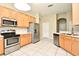 Bright kitchen featuring stainless steel appliances, wood cabinets, and tile flooring for easy maintenance at 77 Spring Glen Dr, Debary, FL 32713