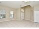 Open-concept living room featuring tile floors, large windows, and a front entry door at 77 Spring Glen Dr, Debary, FL 32713