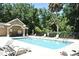 Community pool and cabana with lounge chairs, surrounded by lush landscaping and black metal fence at 77 Spring Glen Dr, Debary, FL 32713