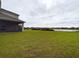 Large grassy backyard with lake view and screened patio at 2506 Volunteer Ave, Kissimmee, FL 34744