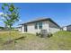 A cozy home backyard featuring a small tree, grassy lawn, and sliding glass door access at 2526 Linda Knoll Ln, Bartow, FL 33830