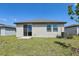 Exterior view of home's backyard with lawn and sliding glass door access to the home at 2526 Linda Knoll Ln, Bartow, FL 33830