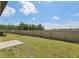A spacious backyard featuring green grass and a long tan fence at 2526 Linda Knoll Ln, Bartow, FL 33830