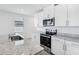 Bright kitchen offers stainless steel appliances, granite counters, and white cabinets at 2526 Linda Knoll Ln, Bartow, FL 33830