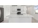 Open kitchen with white cabinets, center island, and stainless steel appliances at 2538 Linda Knoll Ln, Bartow, FL 33830