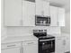 Modern kitchen with white cabinets, stainless steel appliances, and quartz countertops at 2538 Linda Knoll Ln, Bartow, FL 33830