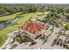 Aerial view of a clubhouse with terracotta roof tiles next to a golf course at 2710 Bolzano Dr, Apopka, FL 32712