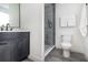 Modern bathroom with dark vanity, glass shower, and gray tile floors at 2902 Sylvan Ave, Orlando, FL 32806