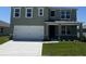 Charming two-story home boasts a large garage, well-manicured lawn, and inviting covered entryway at 3528 Sandalwood Isle Way, Ocoee, FL 34761