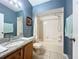 Bathroom with granite vanity, tiled floors, a bathtub, and soft blue walls at 1469 Swan Pl, Kissimmee, FL 34759