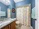 Bathroom with granite vanity, tiled floors, a bathtub, and soft blue walls at 1469 Swan Pl, Kissimmee, FL 34759