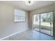 Bright bedroom featuring a window, sliding door and neutral-toned tile floors at 1469 Swan Pl, Kissimmee, FL 34759