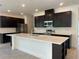 Modern kitchen featuring dark cabinetry, stainless appliances, large island, and sleek countertops at 1664 Andover Ridge Dr, Deland, FL 32720