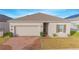 Charming single-story home featuring a brick driveway, attached garage, and well-maintained front yard at 473 Disa Dr, Davenport, FL 33837