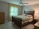 Cozy bedroom with a ceiling fan, decorative bedding, light-grey walls, and wood-look flooring at 11 Sandra Cir, New Smyrna Beach, FL 32168