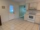 Well-lit kitchen with white cabinetry, tile flooring, and access to the backyard at 11 Sandra Cir, New Smyrna Beach, FL 32168
