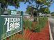 Community entrance sign for Hidden Lakes Golf Course, lush landscaping and parking area at 11 Sandra Cir, New Smyrna Beach, FL 32168