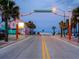 Charming street view of Flagler Avenue with its archway and colorful local businesses and palm trees at 11 Sandra Cir, New Smyrna Beach, FL 32168