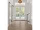 Bright entryway with light wood floors, white doors, and a stylish light fixture at 531 Sanctuary Golf Pl, Apopka, FL 32712