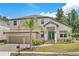 Two-story house with light-colored siding, light brown garage doors, and a landscaped yard at 531 Sanctuary Golf Pl, Apopka, FL 32712