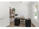 Bright home office featuring a large desk, built-in shelving and hardwood floors at 531 Sanctuary Golf Pl, Apopka, FL 32712
