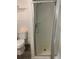 Close-up of a shower with a glass door, a toilet, and a towel rack in a compact bathroom at 766 Carlson Dr, Orlando, FL 32804