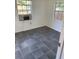 Bedroom with tiled flooring, bright windows, and an air conditioner, providing a comfortable retreat at 766 Carlson Dr, Orlando, FL 32804