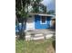 Exterior of a blue single-story home with a small front porch, surrounded by lush greenery at 766 Carlson Dr, Orlando, FL 32804