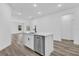 Modern kitchen island with white cabinets and stainless steel dishwasher at 160 Fisher Way Trl, Ocklawaha, FL 32179