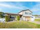 Two-story house with a large wooden garage door, landscaping, and a white picket fence at 610 Alton Rd, Winter Springs, FL 32708