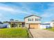 Two-story house with a large wooden garage door, landscaping, and a white picket fence at 610 Alton Rd, Winter Springs, FL 32708