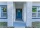 A close-up view of the home's entryway with a bright blue front door and stone facade at 765 W Lansdowne Ave, Orange City, FL 32763