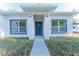 Inviting home exterior featuring a stylish blue front door and manicured lawn at 765 W Lansdowne Ave, Orange City, FL 32763