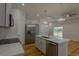 Bright kitchen features stainless steel appliances, light grey cabinetry, and stylish light fixtures at 765 W Lansdowne Ave, Orange City, FL 32763