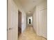 Hallway with neutral walls, tile flooring, and white doors and trim, leading to other rooms in the home at 8343 Bella Tierra Ct # 8343, Davenport, FL 33896
