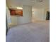 Open living area with carpeted floors and an eat-in kitchen featuring wood cabinets at 8343 Bella Tierra Ct # 8343, Davenport, FL 33896
