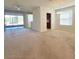 Open living room with neutral walls, plush carpet, and large windows that lead to a screened in patio at 8343 Bella Tierra Ct # 8343, Davenport, FL 33896