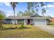 Charming single-Gathering home features a well-manicured front lawn with vibrant landscaping, stone accents, and a two-car garage at 1608 Bomi Cir, Winter Park, FL 32792
