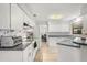 Bright kitchen featuring white cabinets, stainless steel appliances, and wood-look flooring at 1608 Bomi Cir, Winter Park, FL 32792