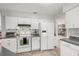 Well-lit kitchen with white cabinetry, stainless steel appliances, and view of a shelving unit with books at 1608 Bomi Cir, Winter Park, FL 32792