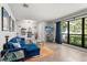 Bright living room showcasing a blue sectional, a large window, and stylish shelving at 1608 Bomi Cir, Winter Park, FL 32792