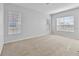 Spacious bedroom with neutral carpeting and two windows at 2620 Sand Arbor Cir, Orlando, FL 32824