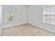 Simple bedroom with neutral carpeting and two windows at 2620 Sand Arbor Cir, Orlando, FL 32824