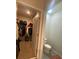 Walk-in closet featuring shelving and hanging racks adjacent to a small water closet at 2723 Sunkissed Dr, St Cloud, FL 34771