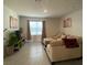 Cozy living room featuring neutral tones, tile flooring, and a comfortable seating arrangement at 2723 Sunkissed Dr, St Cloud, FL 34771