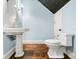 Powder room with pedestal sink and hardwood floor at 907 Moss Ln, Winter Park, FL 32789